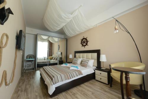 a bedroom with a bed and a table and a chair at Velier Apartment in Mamaia