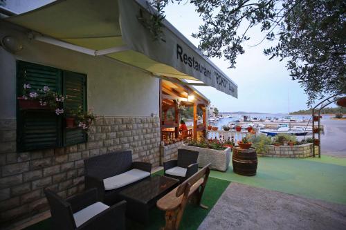 a restaurant with chairs and a table in front of a building at Apartment and rooms Roko in Zaglav