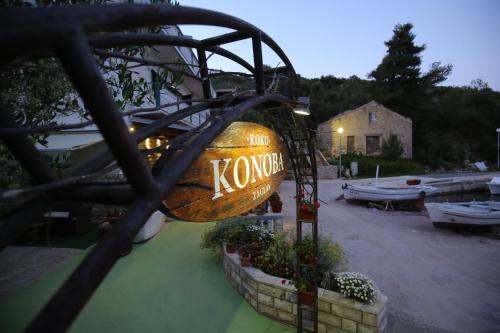 a sign for a kona restaurant with boats in a parking lot at Apartment and rooms Roko in Zaglav