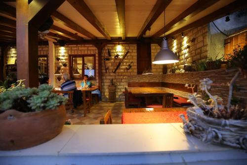 a room with two people sitting at tables in a building at Apartment and rooms Roko in Zaglav