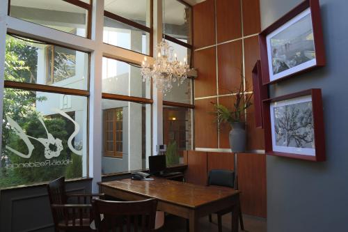 a dining room with a table and a chandelier at Hotel Residencia del Sol in Guatemala
