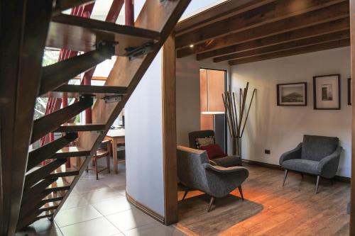 a living room with two chairs and a staircase at Hotel Residencia del Sol in Guatemala