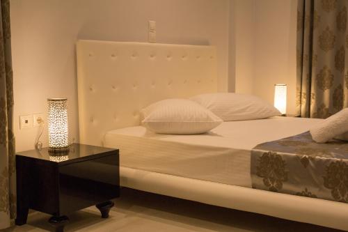 a bedroom with a bed with a table and a lamp at Mare Studios Exclusive in Plomarion