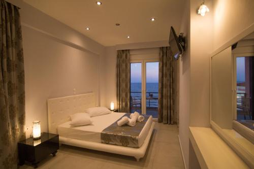 a bedroom with a bed with a view of the ocean at Mare Studios Exclusive in Plomarion