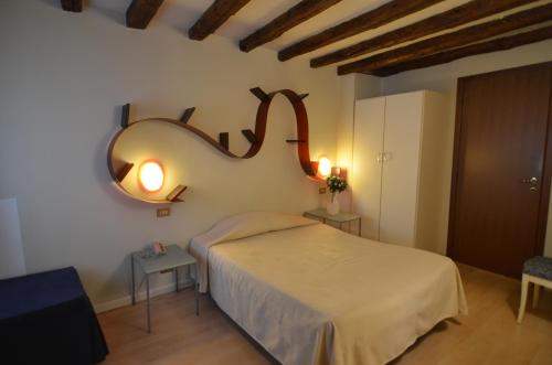 a bedroom with a bed and a mirror on the wall at Piccolo Tiepolo in Venice