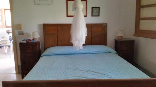 カヴァ・ダリーガにあるUn Giardino Di Pomelie Sul Mareのベッドルーム1室(上にドレスが掛けられたベッド1台付)