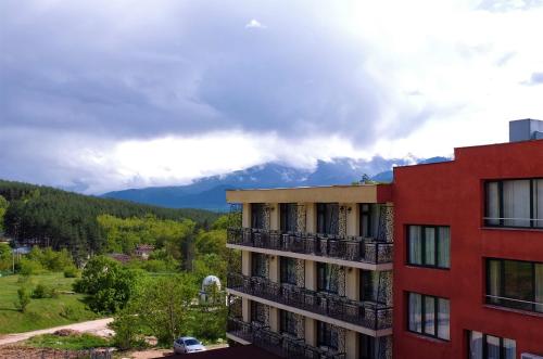 een uitzicht op een gebouw met bergen op de achtergrond bij Spa Away Mountain Suite - Hot Healing and Thermal Bathtub Waters - No Pool in Pchelin