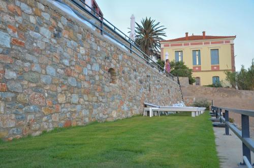 a stone wall with a bench next to a building at Mare Studios Exclusive in Plomarion