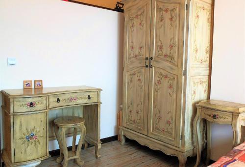 a room with a wooden cabinet and a stool and a table at Ma-Bebe SPA Suite - Thermal Jacuzzi and Family Comfort in Pchelin