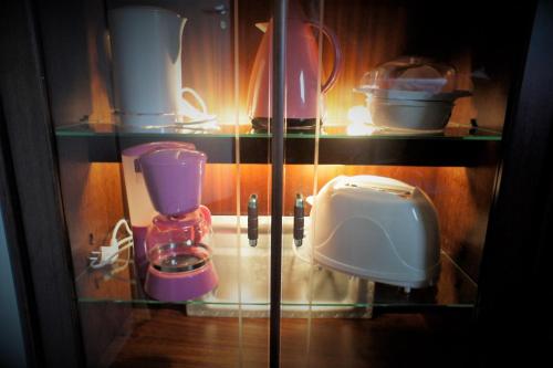 Berge & Laila's Private Apartment في فورد: خزانة زجاجية مع أجهزة مختلفة في المطبخ