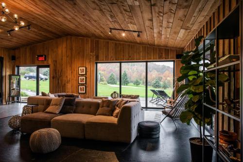 ein Wohnzimmer mit einem Sofa und einem großen Fenster in der Unterkunft Beatnik Hotel in Bromont