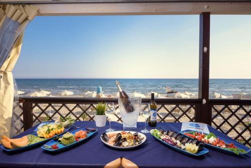 una mesa con platos de comida y el océano en Nenà Al Borgo Castello, en Pico