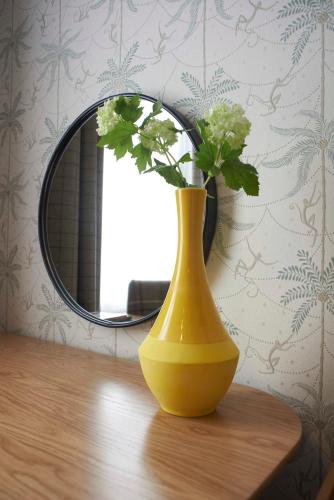 a yellow vase sitting on a table in front of a mirror at Embankment Hotel in Bedford