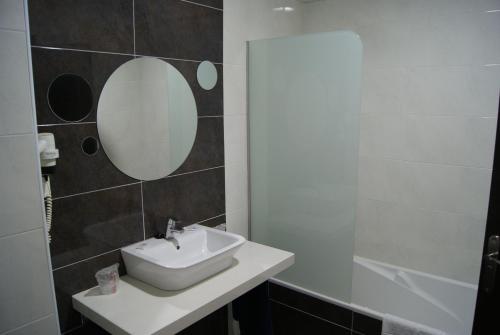 ein Badezimmer mit Waschbecken und Spiegel in der Unterkunft Hotel Doña Luisa in San Luis de Sabinillas