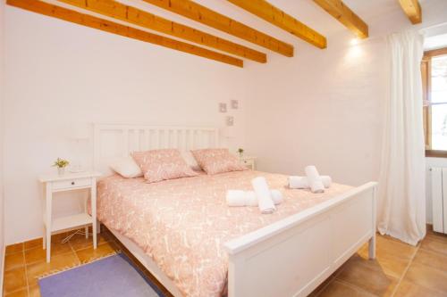 a white bedroom with a bed and a desk at Can Sucre in Sóller