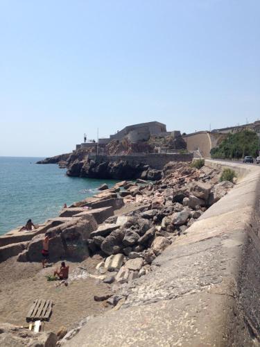 a group of people sitting on a rocky beach at Résidence avec piscine et box, vue sur mer in Sète