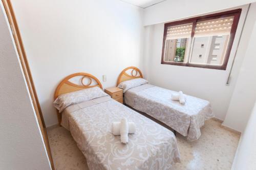 two beds in a small room with a window at Navegante in Gandía
