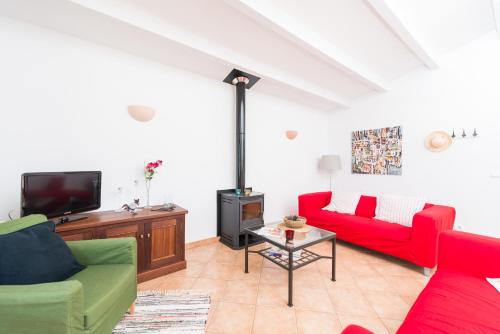 a living room with red and green furniture and a tv at Son Bou in Sóller