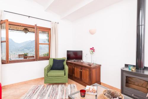 a living room with a green chair and a television at Son Bou in Sóller