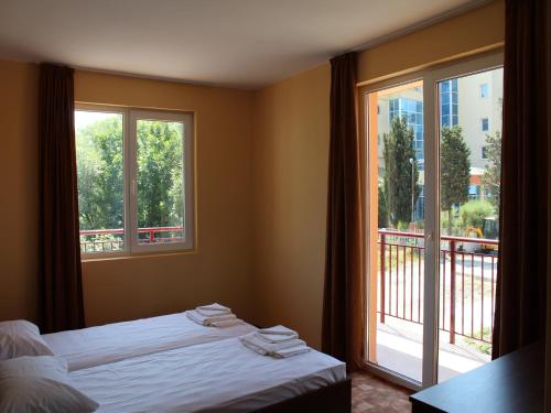 a bedroom with a bed and a large window at Hotel Sapphire in Primorsko