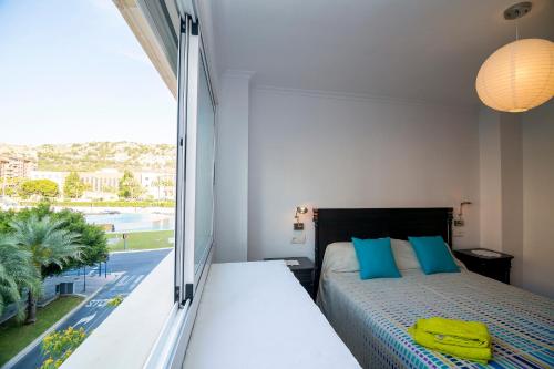 ein Schlafzimmer mit einem Bett und einem großen Fenster in der Unterkunft Apartamento Vistahermosa in Alicante