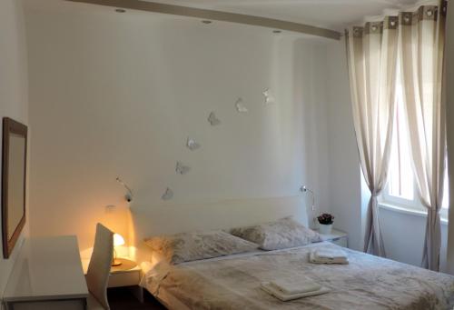 a bedroom with a bed and a desk and a window at Apartment & room Ivan in Šibenik