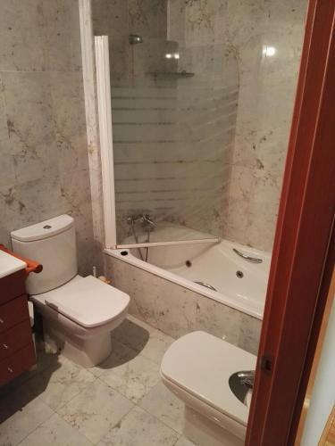 a bathroom with a toilet and a tub and a sink at Apartamento en Playa Capellans in Salou