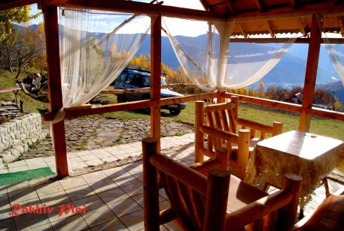a screened in porch with a table and chairs at Rakhiv Plai in Rakhiv