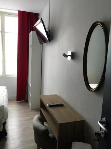 a room with a mirror and a table with a chair at Hotel Ar Terra Nova in Saint Malo