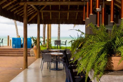 a restaurant with tables and chairs and the beach at Flor de Lis Exclusive Hotel in Maceió