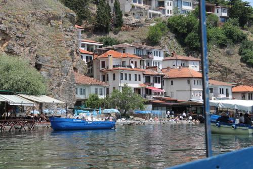 een groep mensen op een strand met boten in het water bij Guest House Ohrid Trpeski in Ohrid