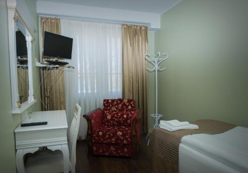 a room with a bed and a desk and a chair at Hotel Golden Dome Iisalmi in Iisalmi