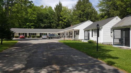 a row of houses with cars parked in the driveway at Franconia Notch Motel in Lincoln