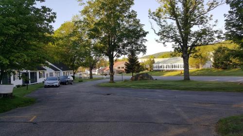 a street in a residential neighborhood with trees and a house at Franconia Notch Motel in Lincoln
