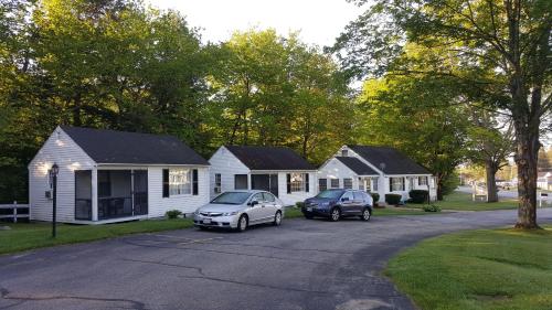 two cars parked in a parking lot in front of houses at Franconia Notch Motel in Lincoln