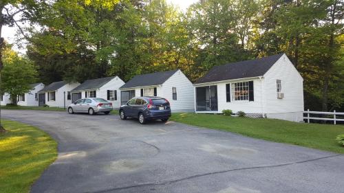 a row of white houses with cars parked in the driveway at Franconia Notch Motel in Lincoln