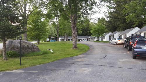 a street with cars parked on the side of a house at Franconia Notch Motel in Lincoln