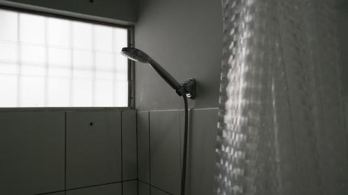 y baño con ducha y ventana. en Tropico Inn, en Paramaribo