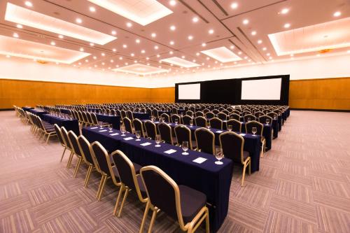 a conference room with rows of chairs and a screen at Occidental at Xcaret Destination - All Inclusive in Playa del Carmen