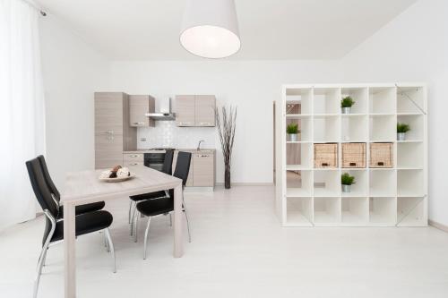 a white kitchen with a white table and chairs at White Flat Termini in Rome