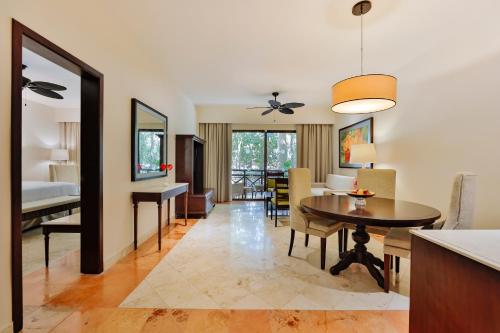 a living room and dining room with a dining table at Occidental at Xcaret Destination - All Inclusive in Playa del Carmen