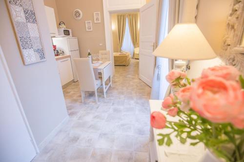 a living room and kitchen with a table and flowers at Edonè Holiday Home in Syracuse