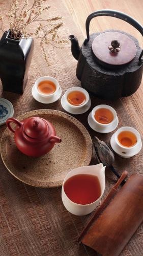 a table with a pot of tea and bowls of soup at Farmhouse Boutique Backyard Rooms in Outjo