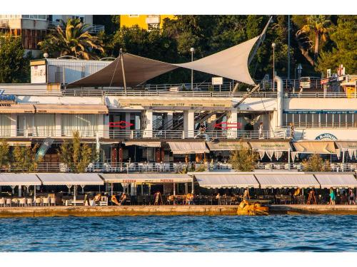 a large building with tables and chairs next to the water at IDRO Studio Apartments directly at the beach in Split