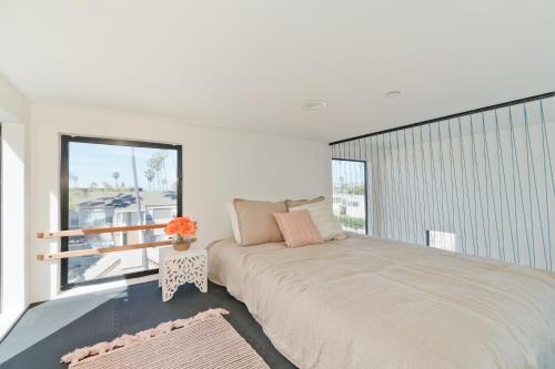 a bedroom with a large bed and a large window at Modern Beach Home Steps To The Sand in San Diego