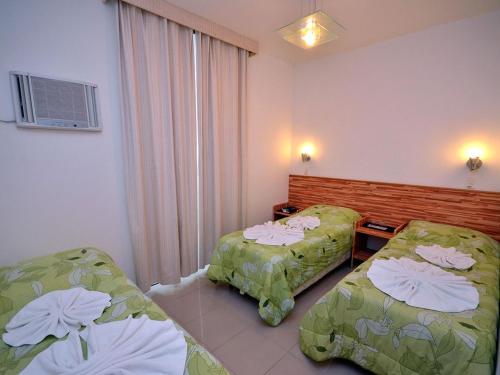 ein Hotelzimmer mit zwei Betten und einem Fenster in der Unterkunft Pousada Omnimare in Ubatuba