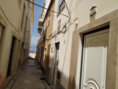 an alley with a door to a building at Familia Sequeira in Nazaré