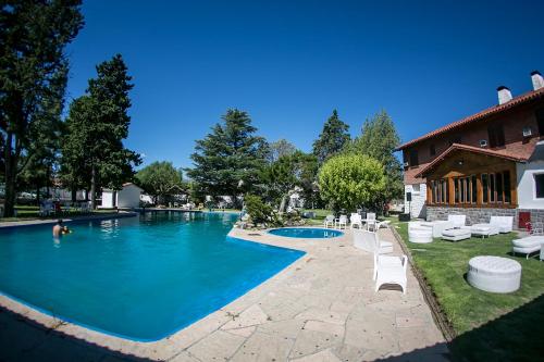 einen Pool mit weißen Stühlen und ein Haus in der Unterkunft Hotel Dos Venados in San Luis