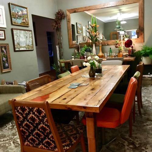 a wooden table in a living room with chairs at Vine Valley Inn in Cessnock