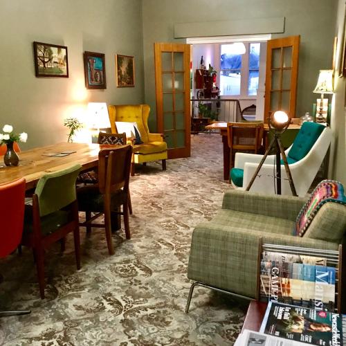a living room with a table and chairs at Vine Valley Inn in Cessnock